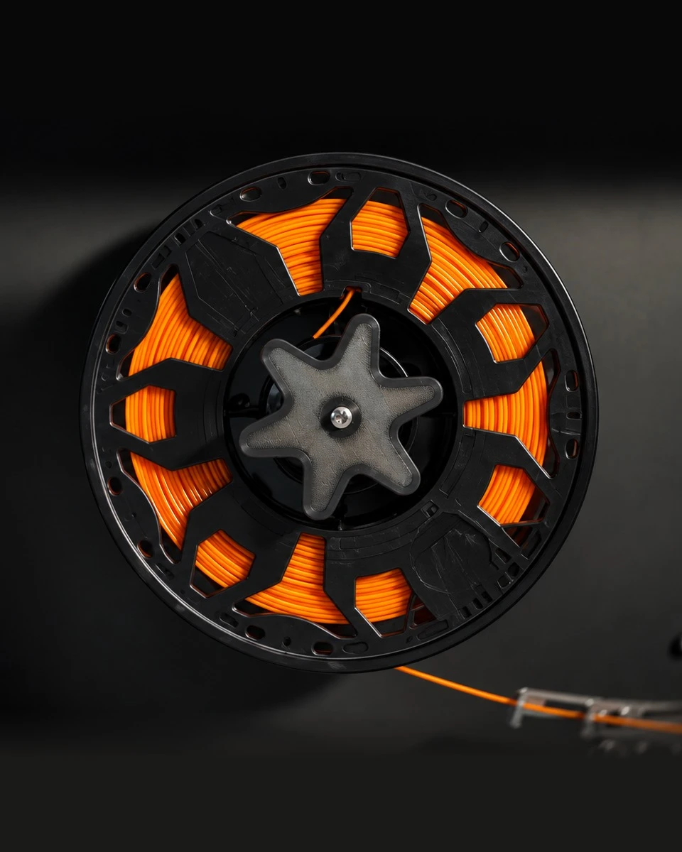 Orange filament wound onto a spool in the ASTER-C spooling bay